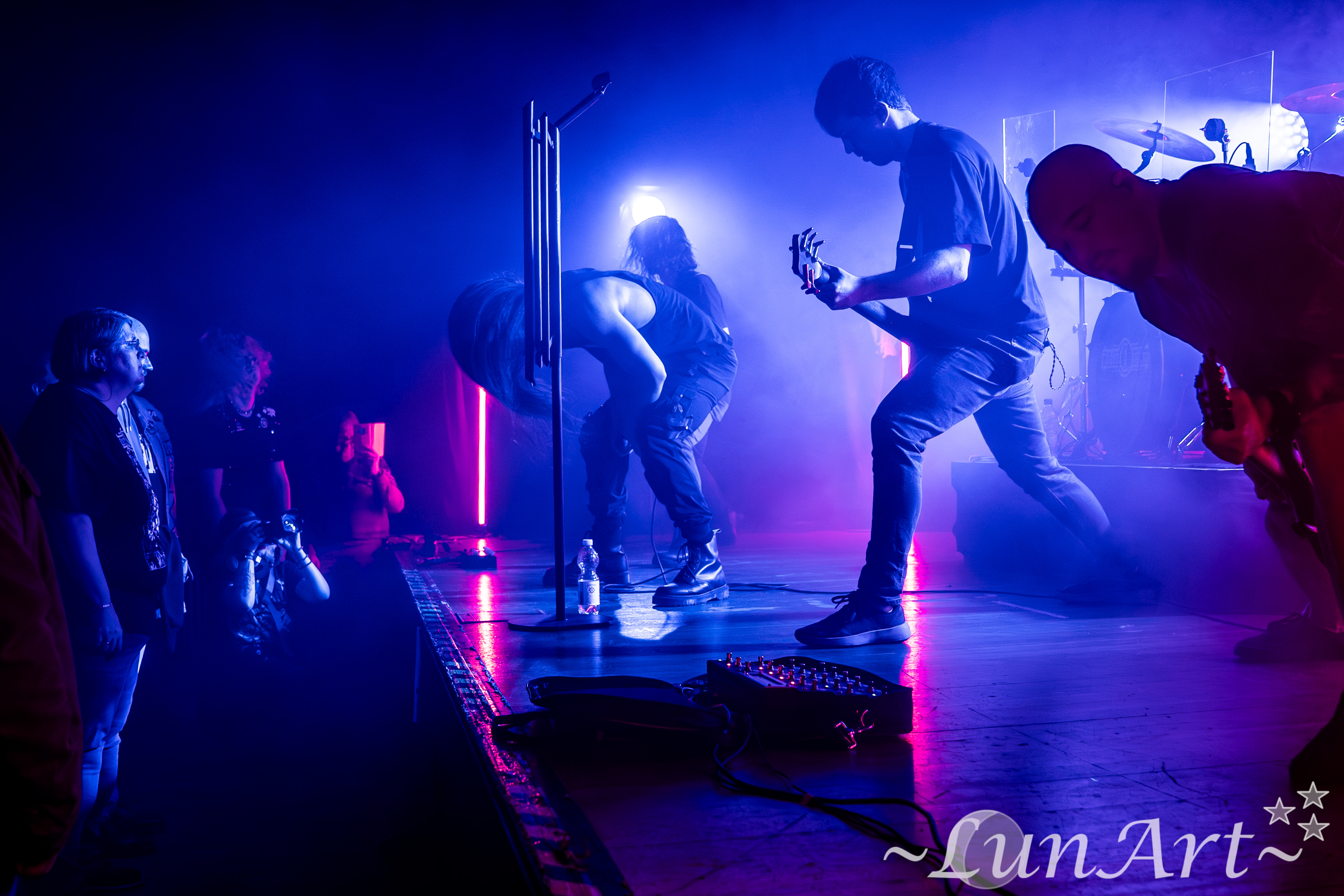 Chris playing bass on stage under red lighting
